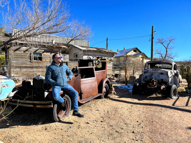 Tourist is taking a break from his road trip along Route 66 in Hackberry, Arizona, enjoying the sunny weather and the sight of vintage rusty cars