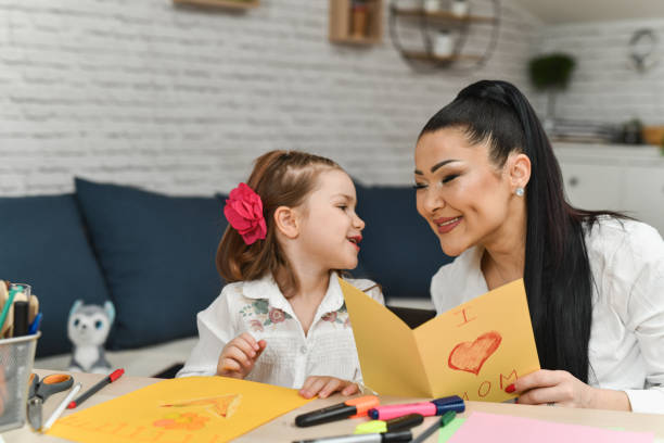 istock Beautiful Mother Reading Daughter's Card With Joy and Smile on Her Face 2204704624