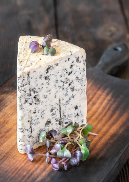 istock Wedge of Roquefort cheese resting on a rustic wooden cutting board 2204707932