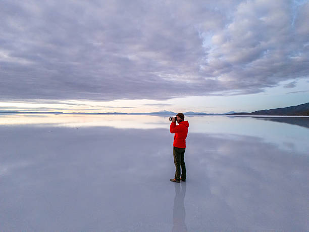 istock Photographer Capturing Reflections on Salt Flats at Sunrise 2204709939