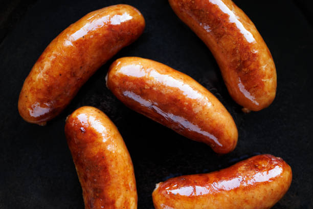 istock Fried pork sausages on black background, close-up view 2204711747
