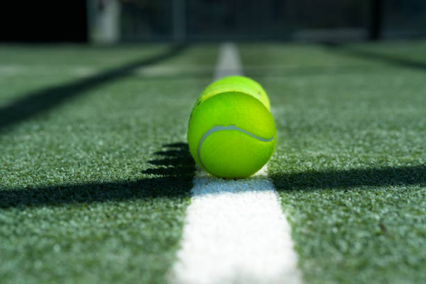 istock tennis balls resting on a white line 2204713549