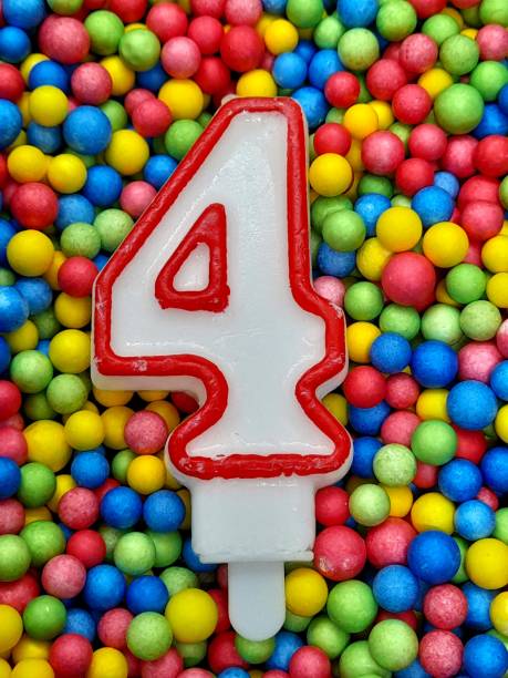 istock Number 4 birthday candle with colorful balls. 2204715934