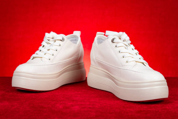 istock womens white sneakers on red background 2204723813