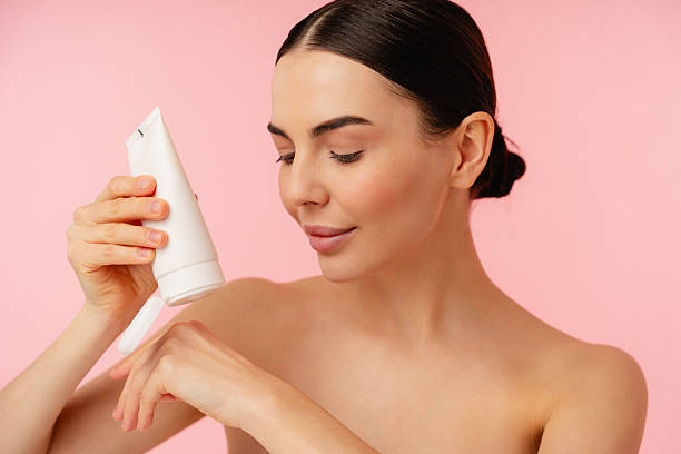 istock Enjoying Skin Care Routine With Lotion on Soft Pink Background 2204724840