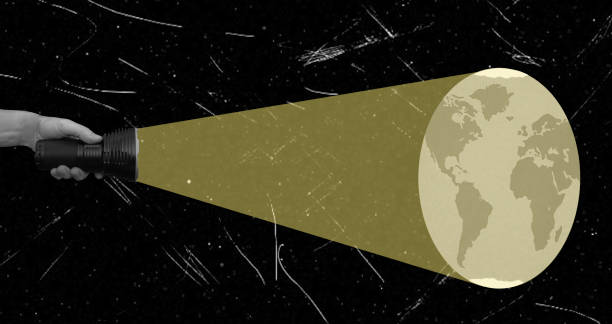 A hand holds a flashlight that projects the Earth onto a starry background, symbolizing exploration and connection to our planet amidst vast darkness, evoking curiosity and wonder.
