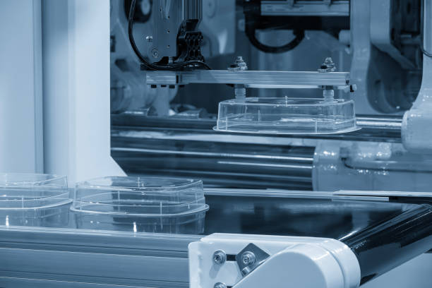 close up scene material handling process the food container by robotic system from injection machine. - material handling conveyor - fotografias e filmes do acervo