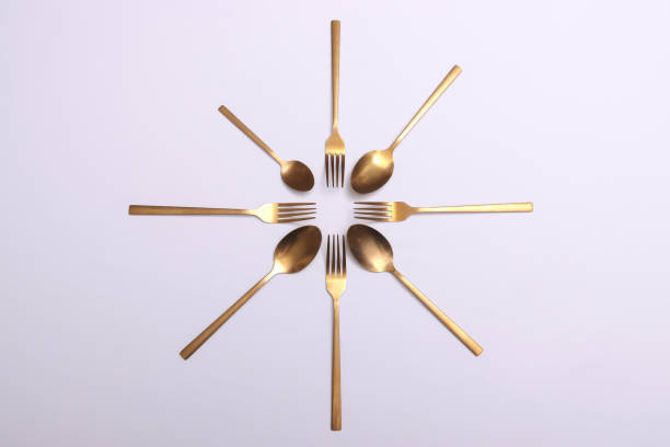 istock Gold cutlery on white shinny silk satin 2204729310