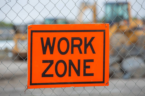 istock Orange work zone sign at a construction site with a bulldozer in the background 2204732570