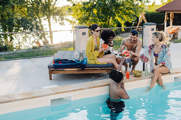 istock Friends eating watermelon by the poolside on summer vacation 2204734551