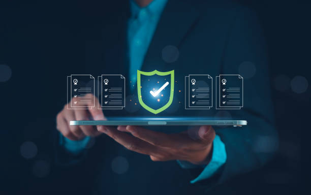 A person in a suit holds a tablet displaying digital security icons, symbolizing data protection and technology.