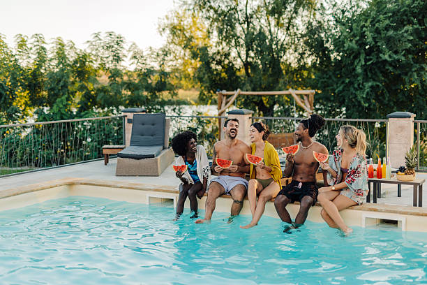 istock Friends eating watermelon by the poolside during summer vacation 2204734611