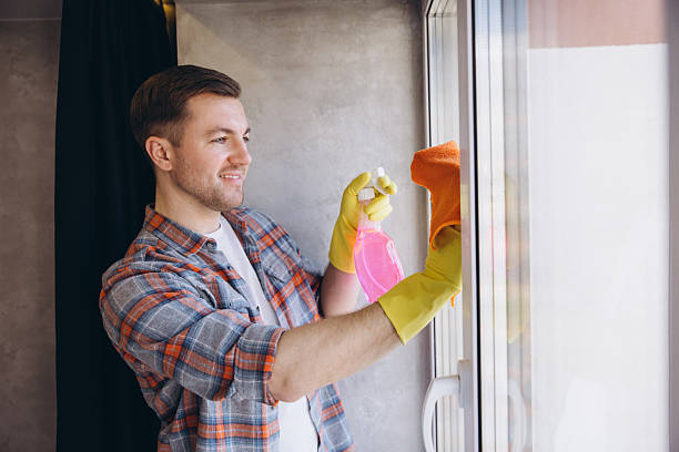 istock Janitor Cleaning Window Glass with Detergent and Cloth 2204737220