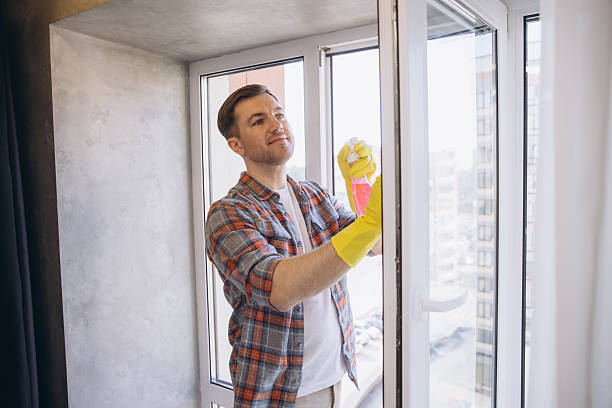 istock Janitor Cleaning Window Glass with Spray Bottle and Cloth 2204737294