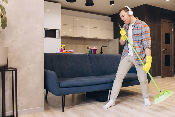 istock Man Singing and Dancing While Cleaning Living Room Floor with Broom 2204739014