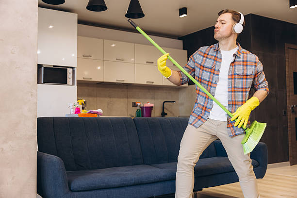 istock Man having fun while cleaning his apartment using broom as guitar 2204739040