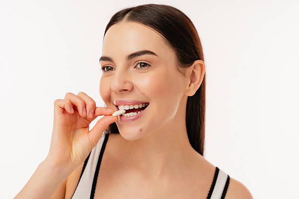 istock Attractive Smiling Individual Holding a Supplement Pill in Fresh Setting 2204740363