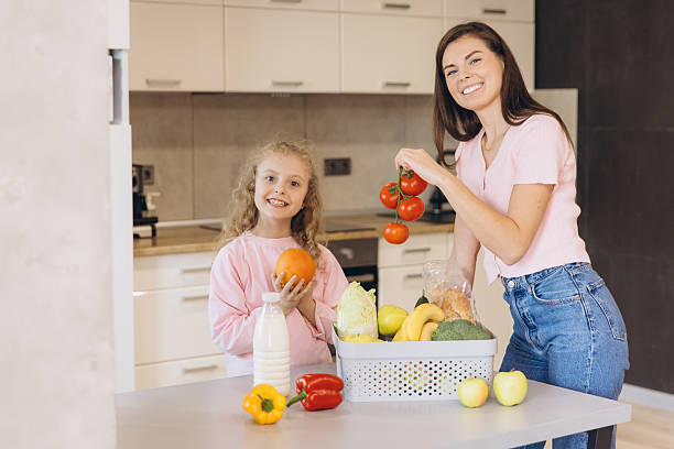 istock Mother and Daughter unpacking fresh groceries in kitchen 2204741414