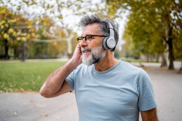 istock Mature man with headphones in the park 2204741675