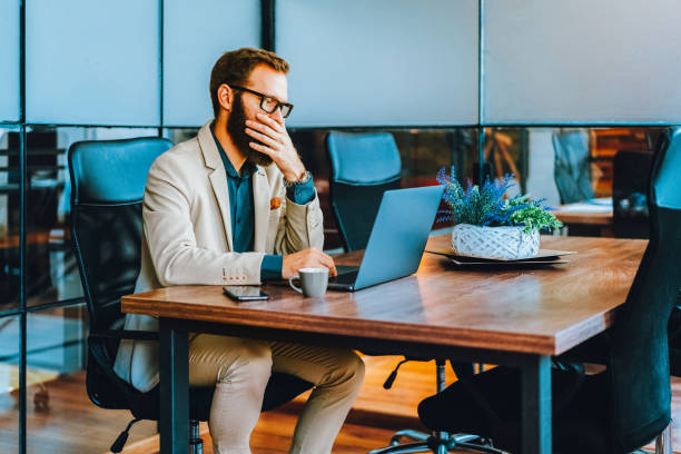 istock Stressed businessman working on laptop at office desk 2204744195