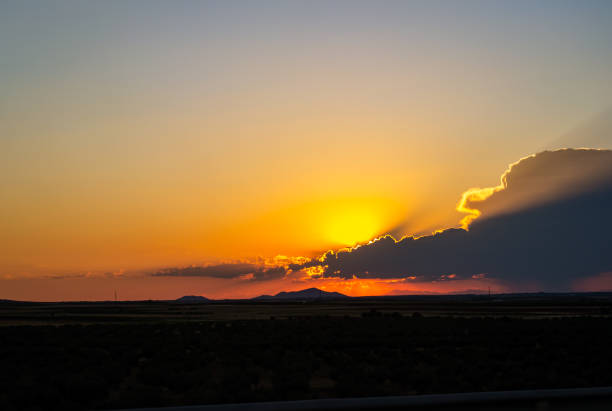 Sunset in orange and blue colors with a mountain background and a cloud in the sky