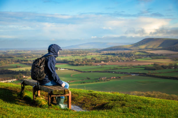 istock Hiker sitting on bench looking at view on South Downs in southeast England 2204746060