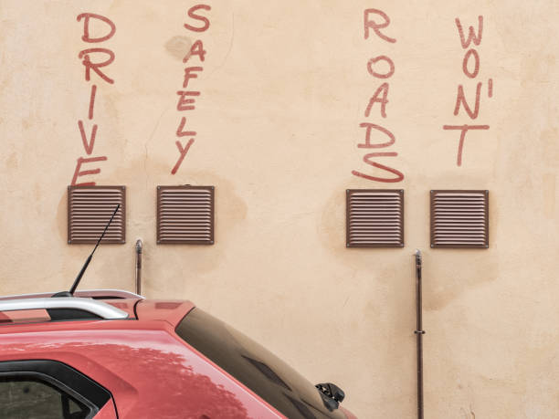 A bold message about road safety is painted on a textured wall, stating \