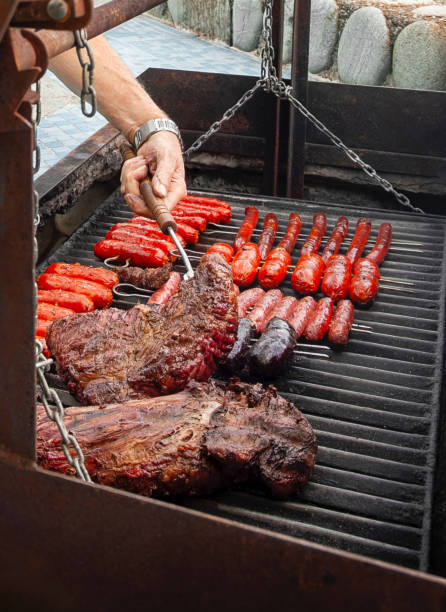 istock Chef grilling sausages and meat on a large barbecue grill 2204748200