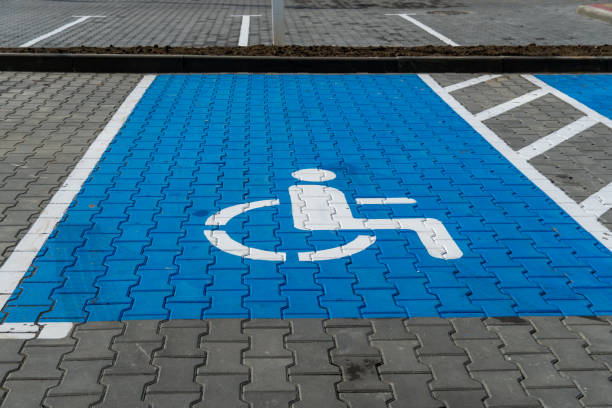 istock A designated accessible parking space features a blue background and a white wheelchair symbol, clearly marked in a well-maintained public parking lot 2204748923