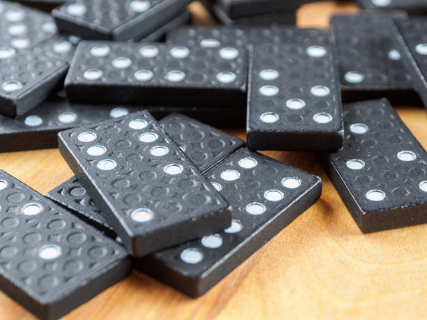 istock Dominoes arranged for a game. The tiles are black with white dots a classic pattern-rich image. 2204749298