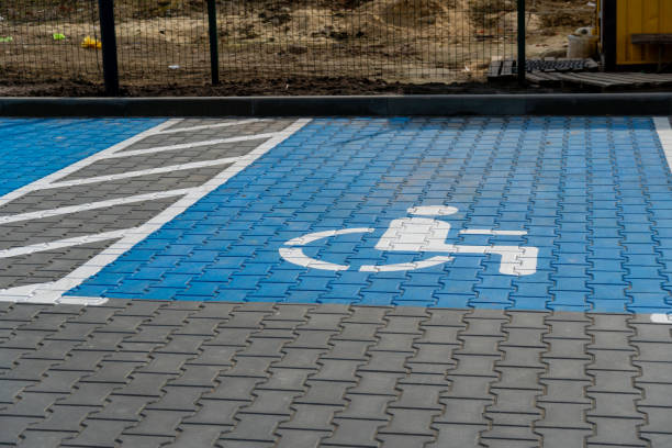 A public parking area features a brightly marked accessible space with blue paving tiles and a clear wheelchair symbol for ease of identification