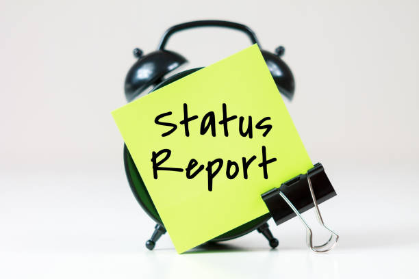 istock Status Report inscription on paper with alarm clock 2204751285