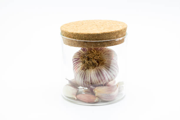 Extra virgin olive oil bottle, garlic, pepper and rosemary on white table