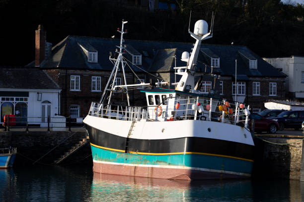 A colourful fishing boat at low tide.