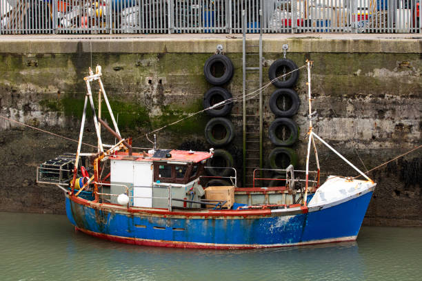 Lyme Regis, Dorset - July 01 2024. Small fishing boat moored in the harbour in the seaside town of Lyme Regis