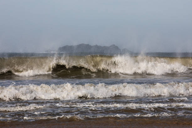 Rough weather and off shore winds create dramatic waves with lots of mist and white spray.