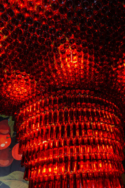 A stunning red glass bottle chandelier creates a mesmerizing glow, adding a unique and artistic ambiance to the space