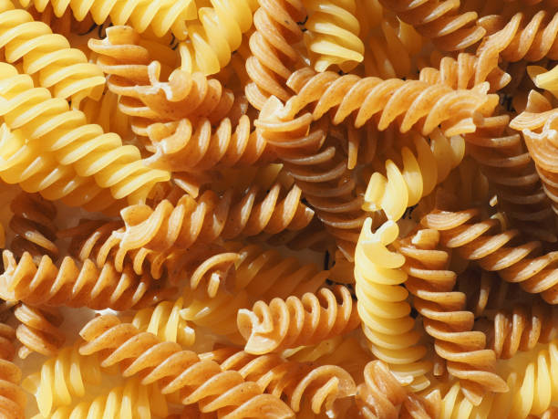 istock mixed regular and whole wheat fusilli pasta background 2204754581