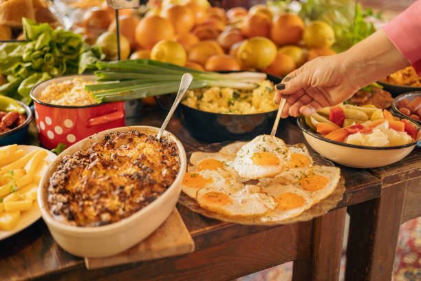 istock Hotel guest picking up fried eggs from buffet table at breakfast 2204754973