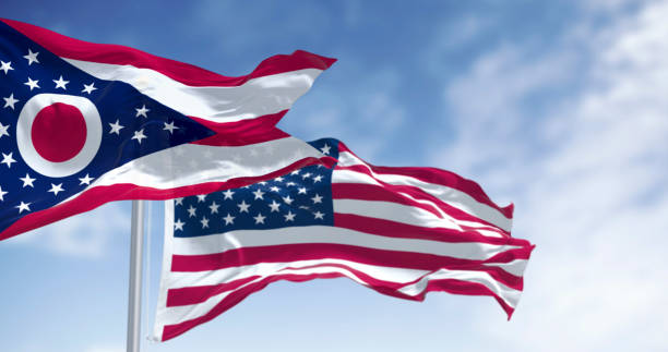 istock Ohio and national US flags waving in the wind on a clear day 2204755241