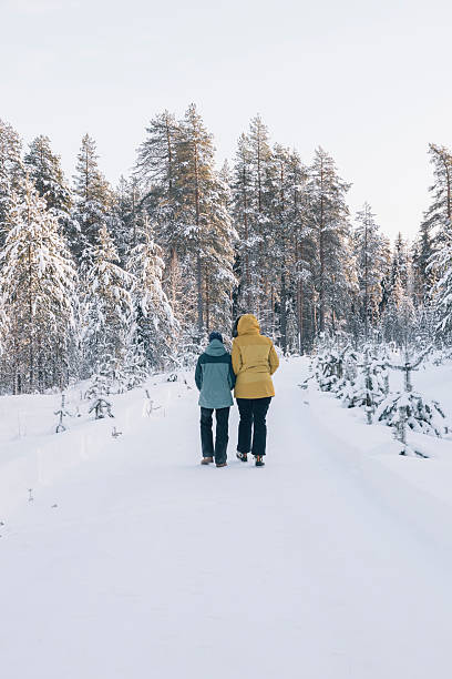 istock Mother and daughter walking in a snowy forest path in winter 2204756209