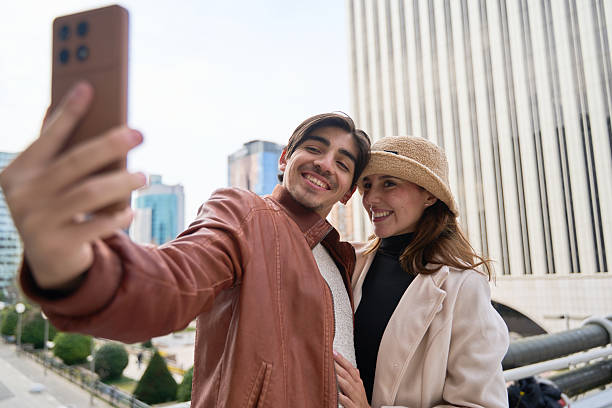 istock Happy couple taking selfie with smartphone in urban setting 2204758332
