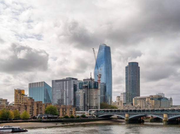 Murky skies over London’s South Bank with Blackfriars railway bridge crossing the River Thames and One Blackfriars tower block (also known as The Boomerang or The Vase) in the centre.