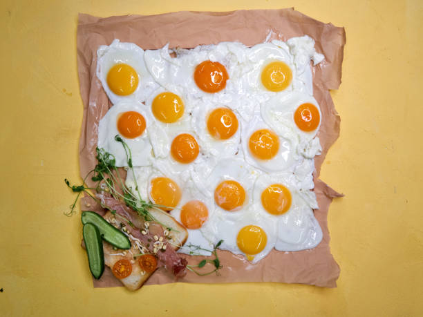 square background of glazed eggs many eggs on yellow background view from above, unusual shape of eggs