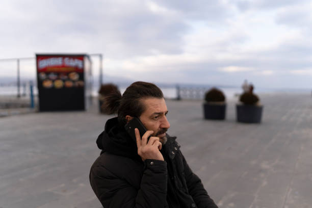 istock Man making a phone call outdoors. 2204763806