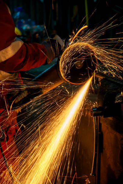 istock A worker cuts a thick metal piece clamped in a vise using a grinding wheel in a workshop. 2204764902