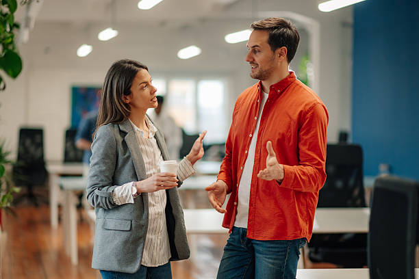 istock Two young business colleagues exchanging ideas during coffee break in modern office 2204767523