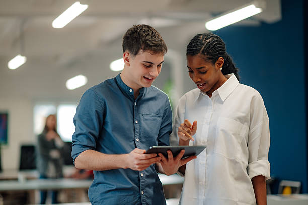 istock Young colleagues collaborating on digital tablet in modern office 2204767629