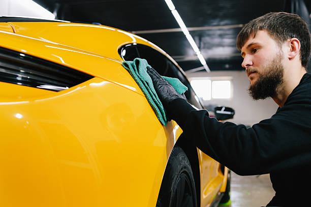 istock Manual washing and polishing car with microfiber cloth after detailing procedure. Microfiber hand cleaning and washing sports car using microfiber towel in garage. 2204768775