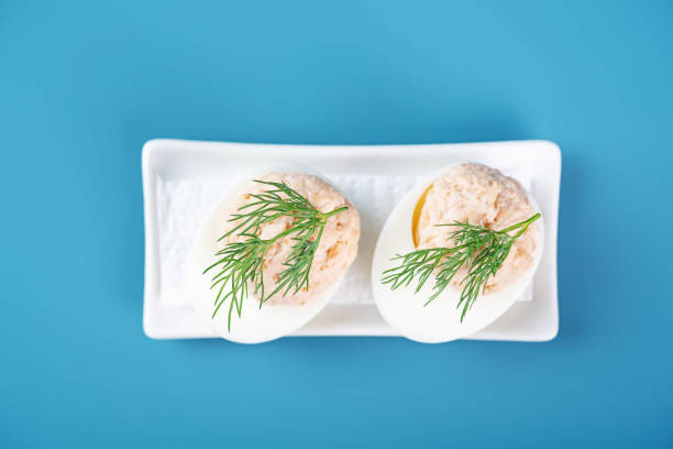 Salmon mousse stuffed eggs with dill on top in a plate for holidays. toning